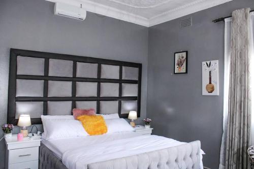 a bedroom with a large white bed with a black headboard at Muwah Palace villa in Johannesburg