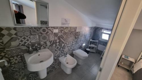 a bathroom with a sink and a toilet and a mirror at The Simo's House Camere a Marzamemi in Marzamemi