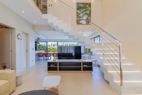 sala de estar con TV y escaleras en SA05 Excelente Casa 5 Suítes - Condomínio Reserva de Sauípe en Costa do Sauipe