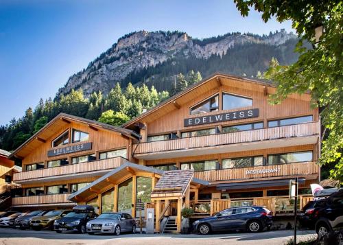a large building with cars parked in front of it at Hotel L'Edelweiss in Pralognan-la-Vanoise