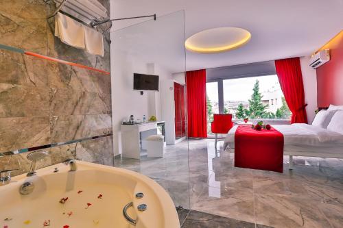 a bathroom with a tub and a bedroom with a bed at Bellezza Hotel Ortakoy in Istanbul