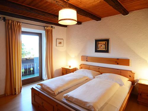 a bedroom with a large bed with a window at Matailerhof in Tirolo