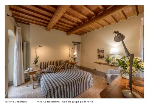 a living room with a bed and a table at Fattoria Casamora - Villa La Nocciolina in Pian di Scò