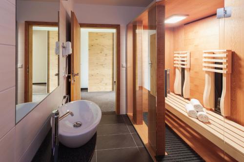 ein Badezimmer mit einem Waschbecken, einem WC und einem Spiegel in der Unterkunft Sapia Hotel Rheinsberg in Bad Säckingen