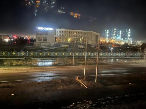 - Vistas a la ciudad por la noche con un edificio en Апартаменты Жасмин, en Karagandá