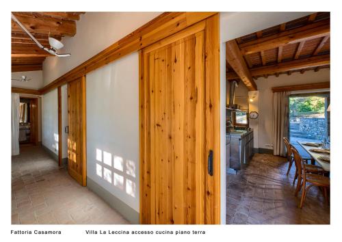 a room with a wooden door and a dining room at Fattoria Casamora - Villa La Leccina in Pian di Scò