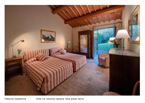 a bedroom with a bed and a couch and a window at Fattoria Casamora - Villa La Leccina in Pian di Scò