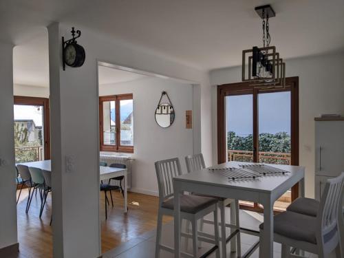 une cuisine et une salle à manger avec une table et des chaises blanches dans l'établissement Maison proche lac, vélos, parking, à Sévrier