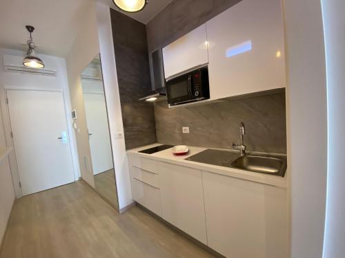 a kitchen with a sink and a microwave at Residenze Romano Ristorante & Spa - albergo diffuso - RED in Foggia
