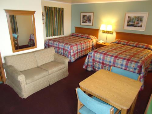 Habitación de hotel con sofá y 2 camas en Tower Motel, en Green Bay