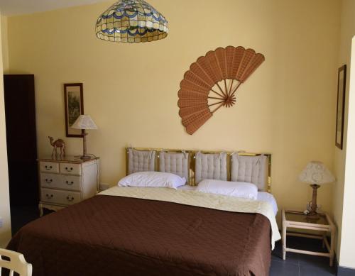 una camera da letto con un letto e un ventilatore a muro di Gmiel in-Natura B&B a Għajn il-Kbira