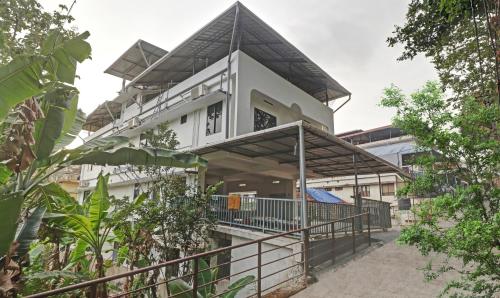 a house with a gambrel roof at Treebo Trend Nirupama Apartment in Alwaye