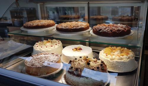 a display case filled with different types of cakes at Hotel Haus am See in Simmerath