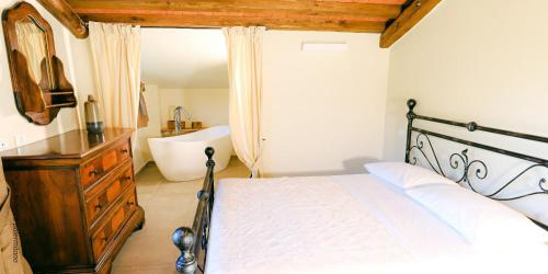 a bedroom with a bed and a bathroom with a tub at Agriturismo I Giunchi in Mochignano