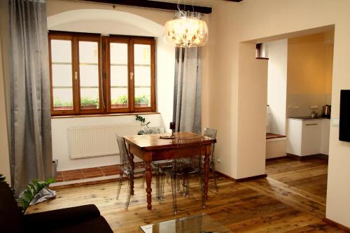 ein Esszimmer mit einem Tisch, Stühlen und einem Fenster in der Unterkunft Apartmany Antico in Mikulov