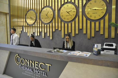 a group of clocks on a wall above a counter at CONNECT THERMAL HOTEL in Ankara