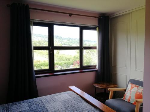 - une chambre avec une fenêtre, un lit et une chaise dans l'établissement Fox Heaven B&B, à Carrickfergus
