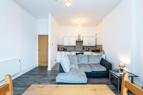 uma sala de estar com um sofá e uma cozinha em One bedroom holiday apartment Colwyn Bay em Colwyn Bay