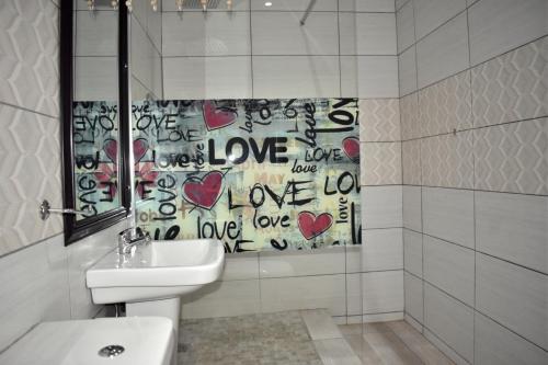 a bathroom with a shower curtain with hearts on it at Iceberg Venue, Guest Lodge & Events place in Benoni