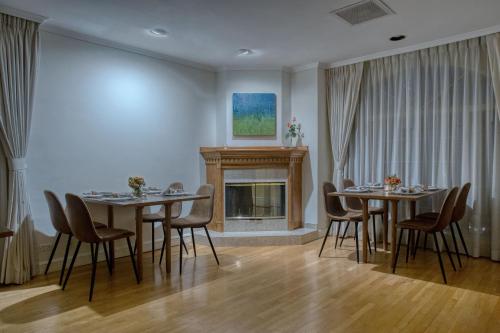 a dining room with two tables and a fireplace at Casa Asturias in Ensenada