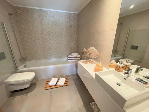 阿爾布費拉的住宿－Villa Cascata, 3 bedroom, Pool, close to Olhos de Agua，浴室配有卫生间、盥洗盆和浴缸。