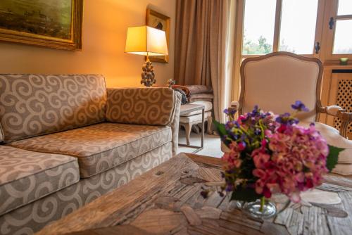 - un salon avec un canapé et une table fleurie dans l'établissement Apartment Chalet Rubihorn mit Berg-Blick, à Bolsterlang