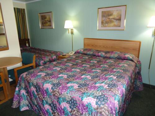 a hotel room with a bed and a table at Tower Motel in Green Bay