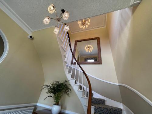 a staircase in a home with a chandelier at Park Farm Hotel in Norwich