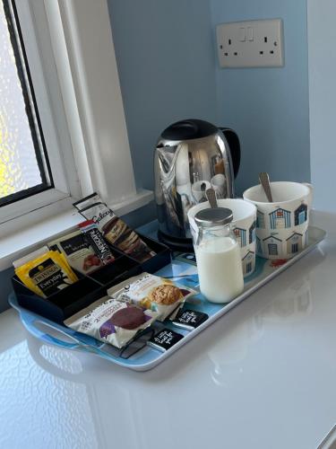 a tray with food and milk on a table at Between the Bays exclusively for Adults in Llandudno