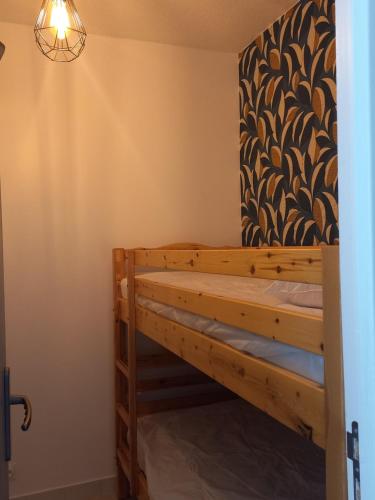 - une chambre avec des lits superposés en bois et une lampe dans l'établissement Appartement climatisé avec terrasse parking piscine et terrains de tennis, au Cap d'Agde