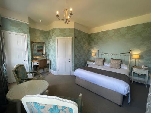 a bedroom with a bed and a table and a chair at Park Farm Hotel in Norwich