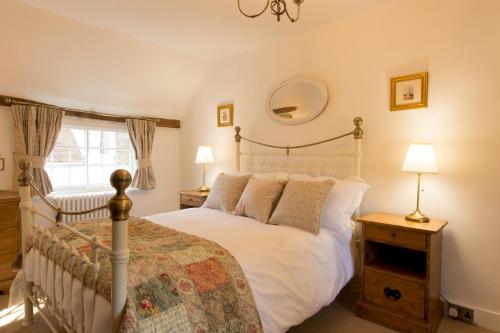 um quarto com uma cama branca e uma janela em Miller Cottage a luxury 1550's cottage in the Historic centre of Saffron Walden em Saffron Walden