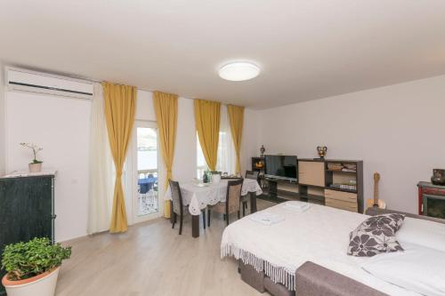 a bedroom with a bed and a table and a television at Apartments Tina in Pag