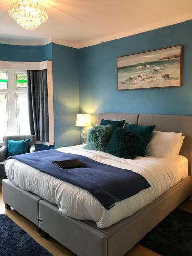 ein Schlafzimmer mit einem großen Bett mit blauen Wänden in der Unterkunft The Drey in Sandown