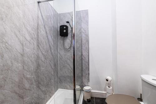 a bathroom with a shower with a toilet and a sink at Two bedroom holiday apartment Colwyn Bay in Colwyn Bay