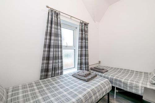 una camera con due letti e una finestra di Two bedroom holiday apartment Colwyn Bay a Colwyn Bay