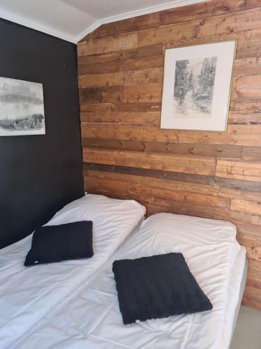 two beds in a bedroom with wooden walls at Lofoten Camp in Stamsund
