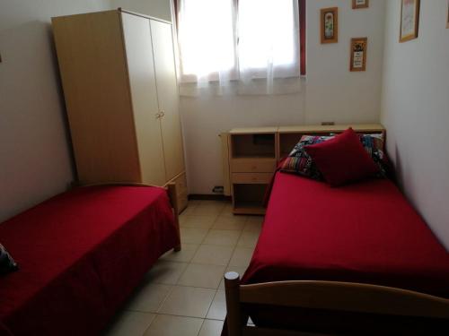 Habitación pequeña con 2 camas y armario en la casa dei bebi, en Carrara