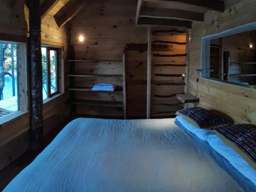 a bedroom with a large bed in a log cabin at Puelo Libre in Llanada Grande