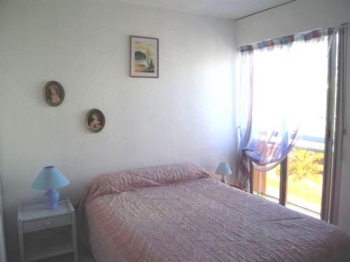 une chambre avec un lit et une grande fenêtre dans l'établissement Appartement 2 pièces climatisé, 300m plages, piscine, à Cavalaire-sur-Mer