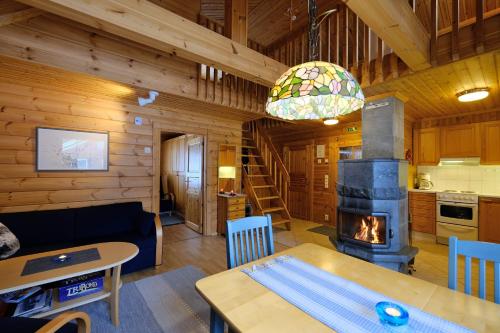 ein Wohnzimmer mit einem Kamin in einer Blockhütte in der Unterkunft Villiporo Cabin Levi in Levi