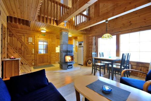 a living room with a fireplace in a log cabin at Villiporo Cabin Levi in Levi
