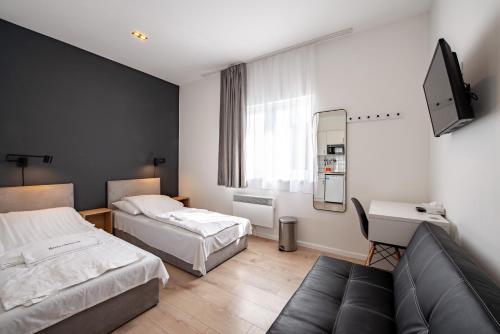 een hotelkamer met 2 bedden en een bank bij Chesscom Apartments in Boedapest