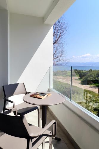 a table and two chairs in a room with a large window at Aphrodite Beach Hotel in Polis Chrysochous