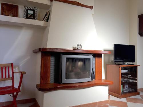 un televisor sentado en una pared en una habitación en Casa Ondina con giardino e Wi-Fi Ussana, en Ussana