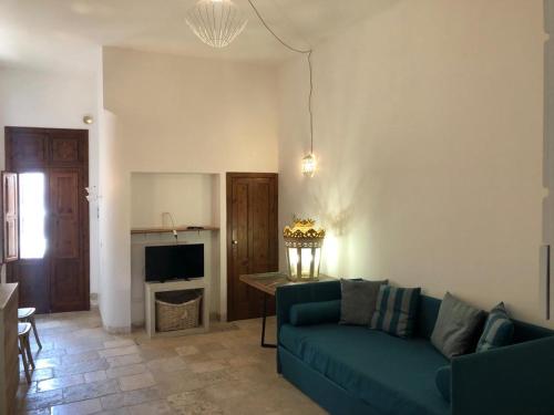 a living room with a blue couch and a table at La Torretta del Senatore in Polignano a Mare
