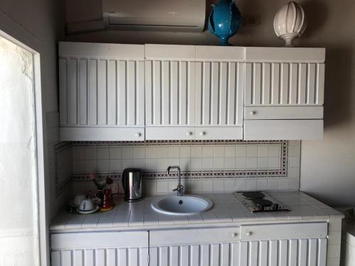 a kitchen with a sink and white cabinets at La Torretta del Senatore in Polignano a Mare