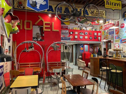 a restaurant with tables and chairs and a red wall at Hôtel Le Boulevardier in Lyon