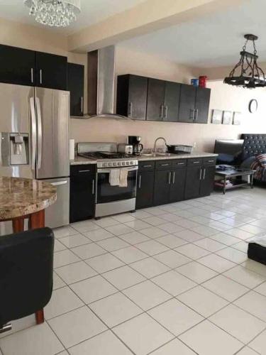 a kitchen with stainless steel appliances and black cabinets at Otay Studio great patio near Otay Crossing & Airport in Tijuana