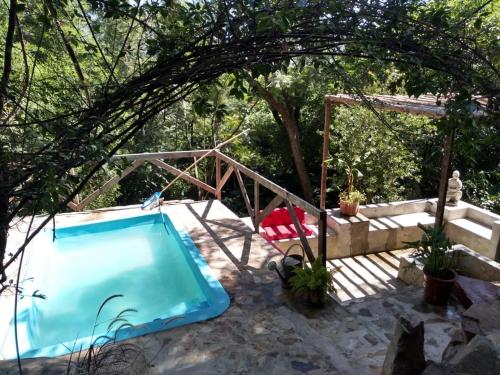 a swimming pool with a tent and a chair in a yard at Namasté Casa Rural in Vaqueros